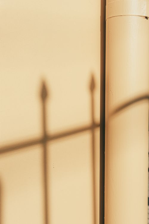 Free Abstract shadow of a fence on a beige wall, highlighting minimalistic design. Stock Photo