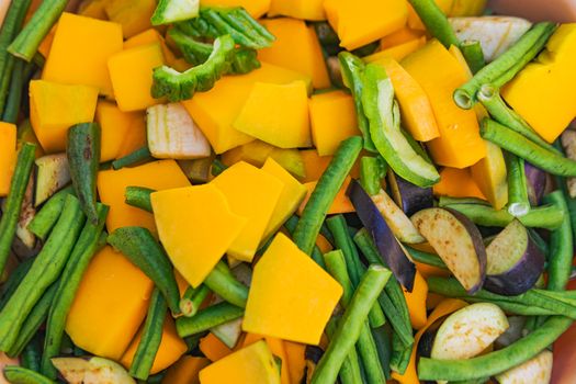 Colorful assortment of freshly cut vegetables including squash, beans, and zucchini.