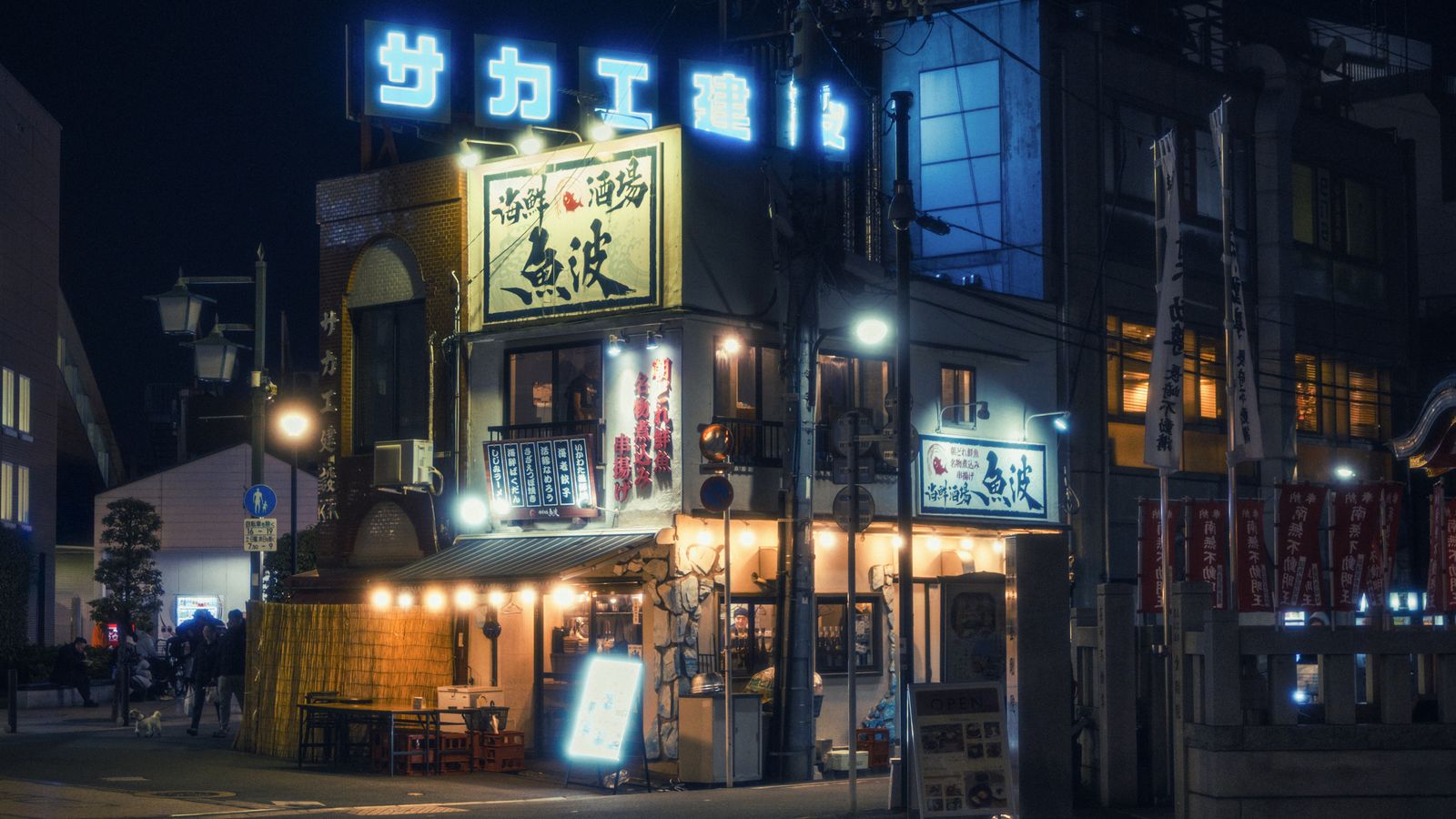 Neon signs glowing over a city street at night, a real stock photo chosen for the neon-soaked look of Night City in Cyberpunk 2077