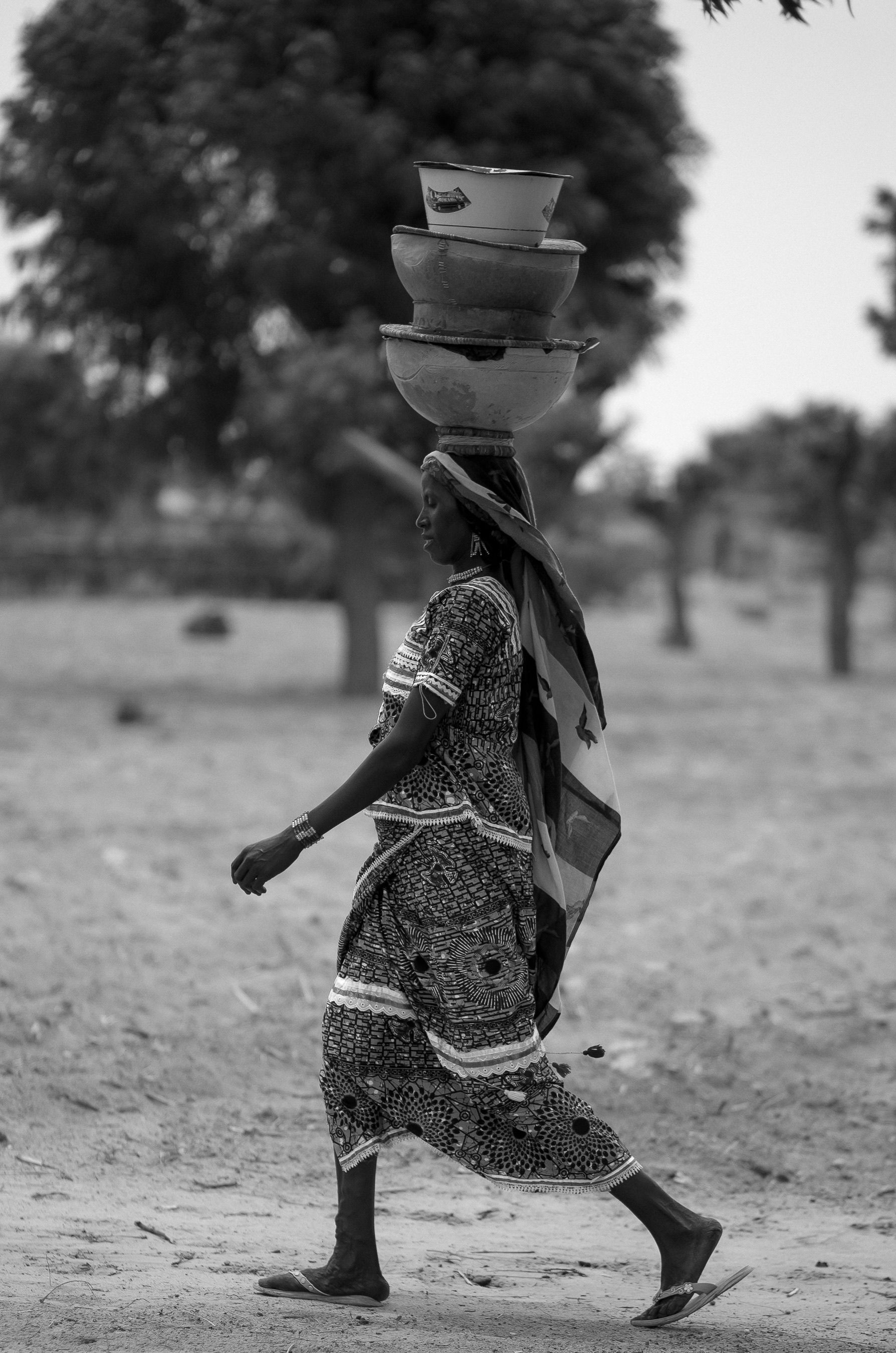 Traditional African Woman Balancing Pots Outdoors · Free Stock Photo