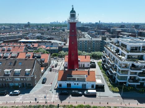 Luchtfoto van de iconische rode vuurtoren van Scheveningen te midden van het stadsgezicht in Den Haag, Nederland.