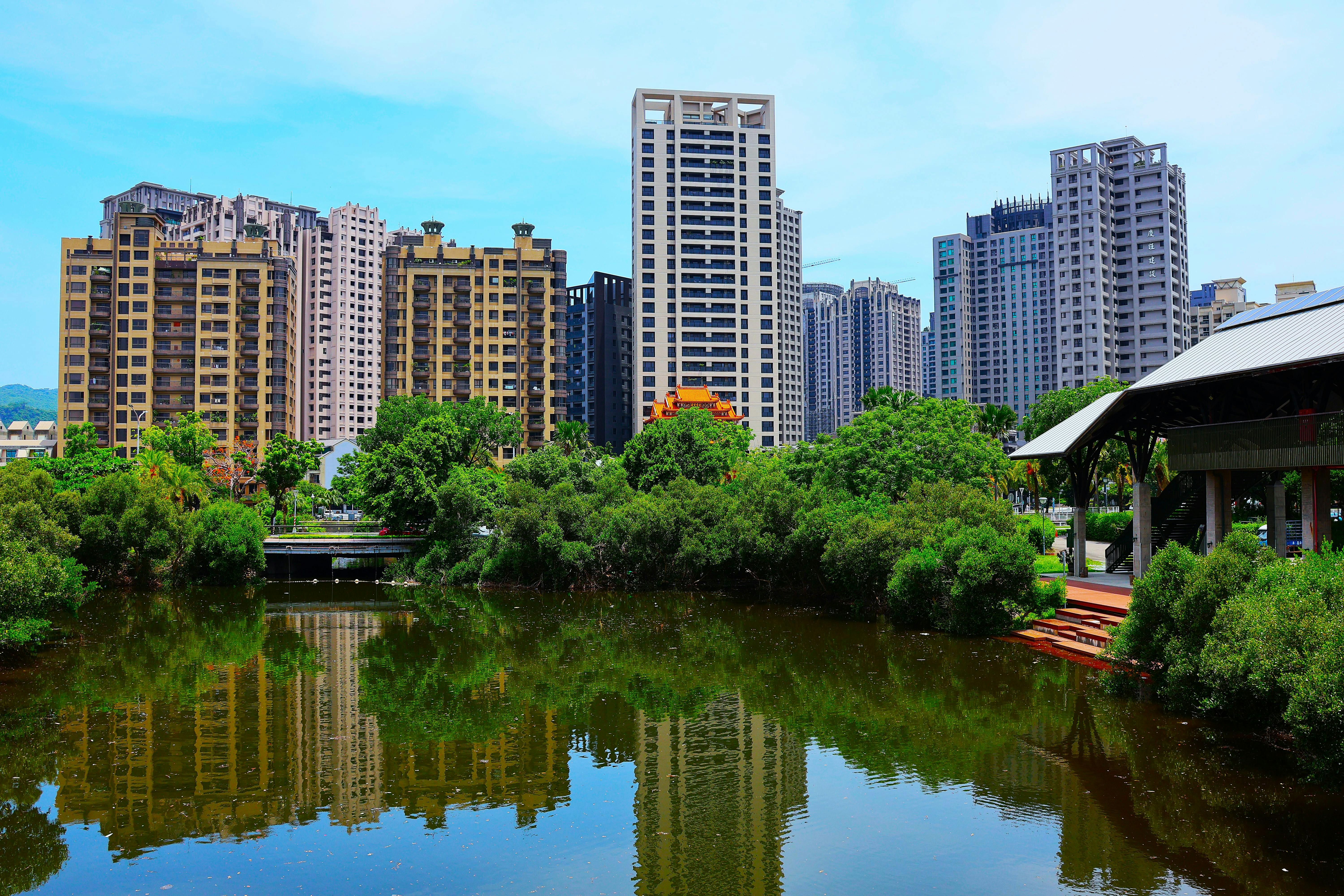 Stunning view of high-rise buildings reflecting in a pond in Kaohsiung City, Taiwan