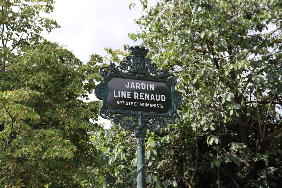 Close-up of the Jardin Line Renaud sign in a leafy Paris park, France.