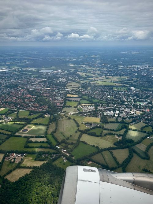 Free Scenic aerial photo showing a mix of farmland and urban areas under cloudy skies. Stock Photo