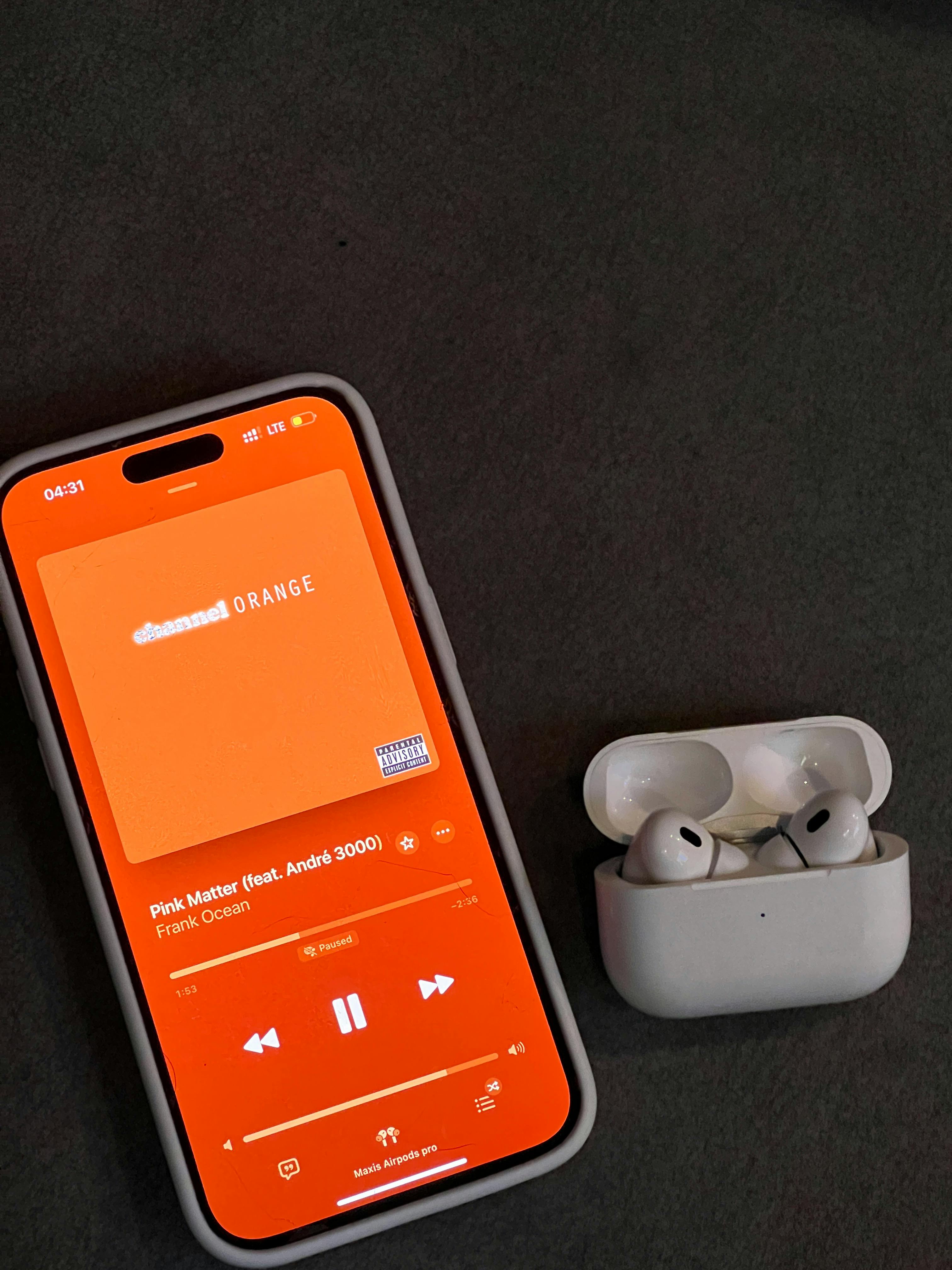 Smartphone con app musicale sullo schermo affiancato da auricolari bianchi