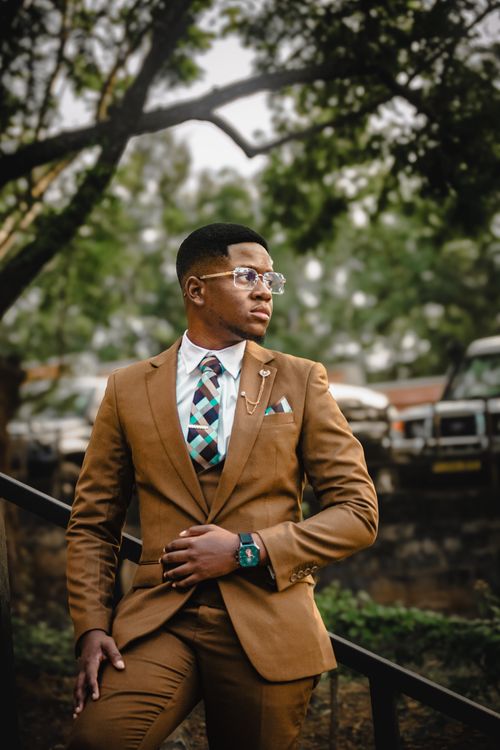 Free Elegant man in brown suit posing outdoors in Dar es Salaam, Tanzania. Stock Photo