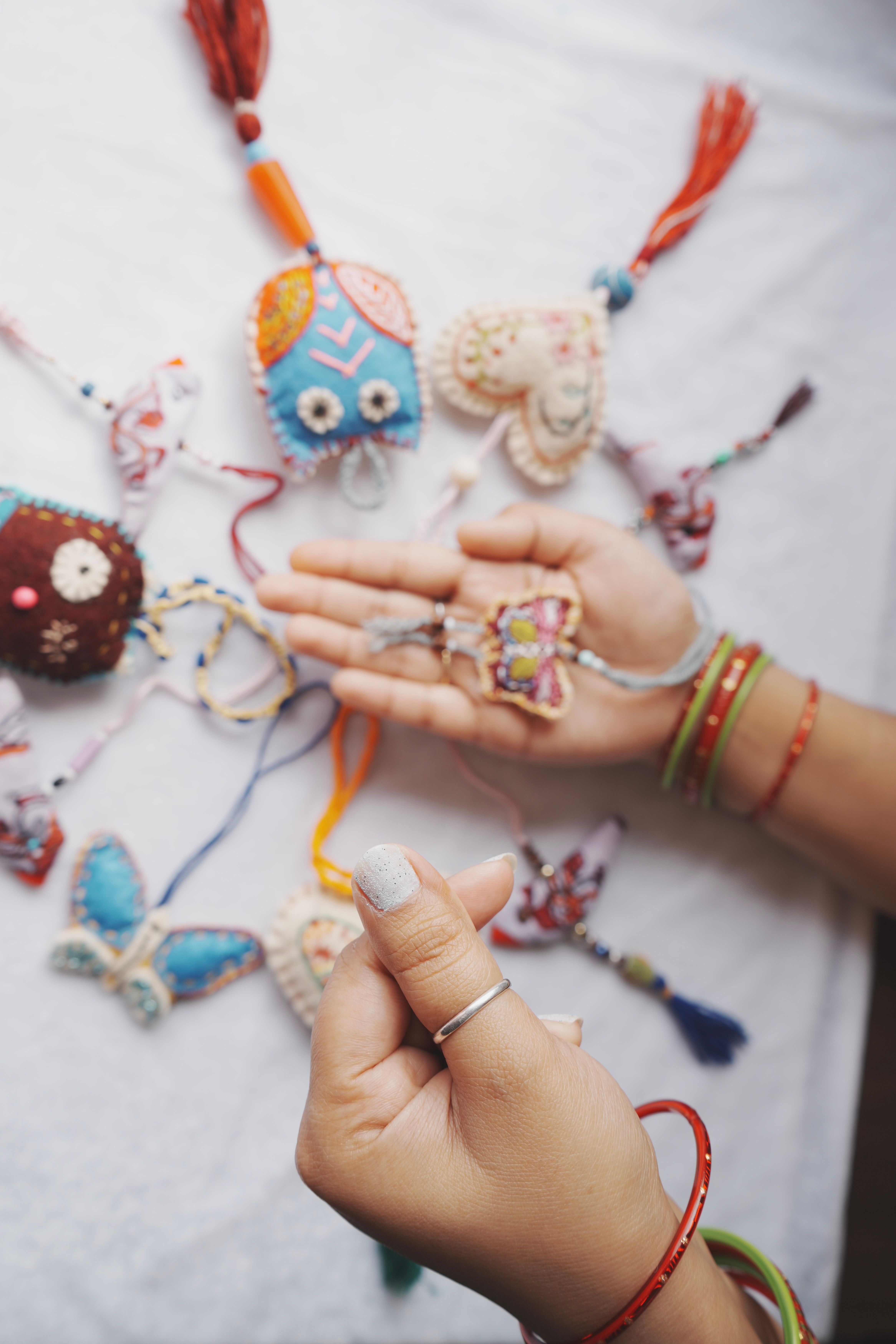 Brightly colored handmade crafts displayed with intricate embroidery on a white surface.