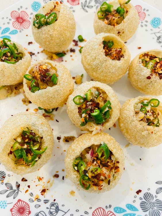 The Delicious Taste of a High-Profit Business Venture A clean, floral plate with freshly made Pani Puri, also known as Golgappe, served with spicy water, highlighting a profitable and hygienic Indian street food business idea.