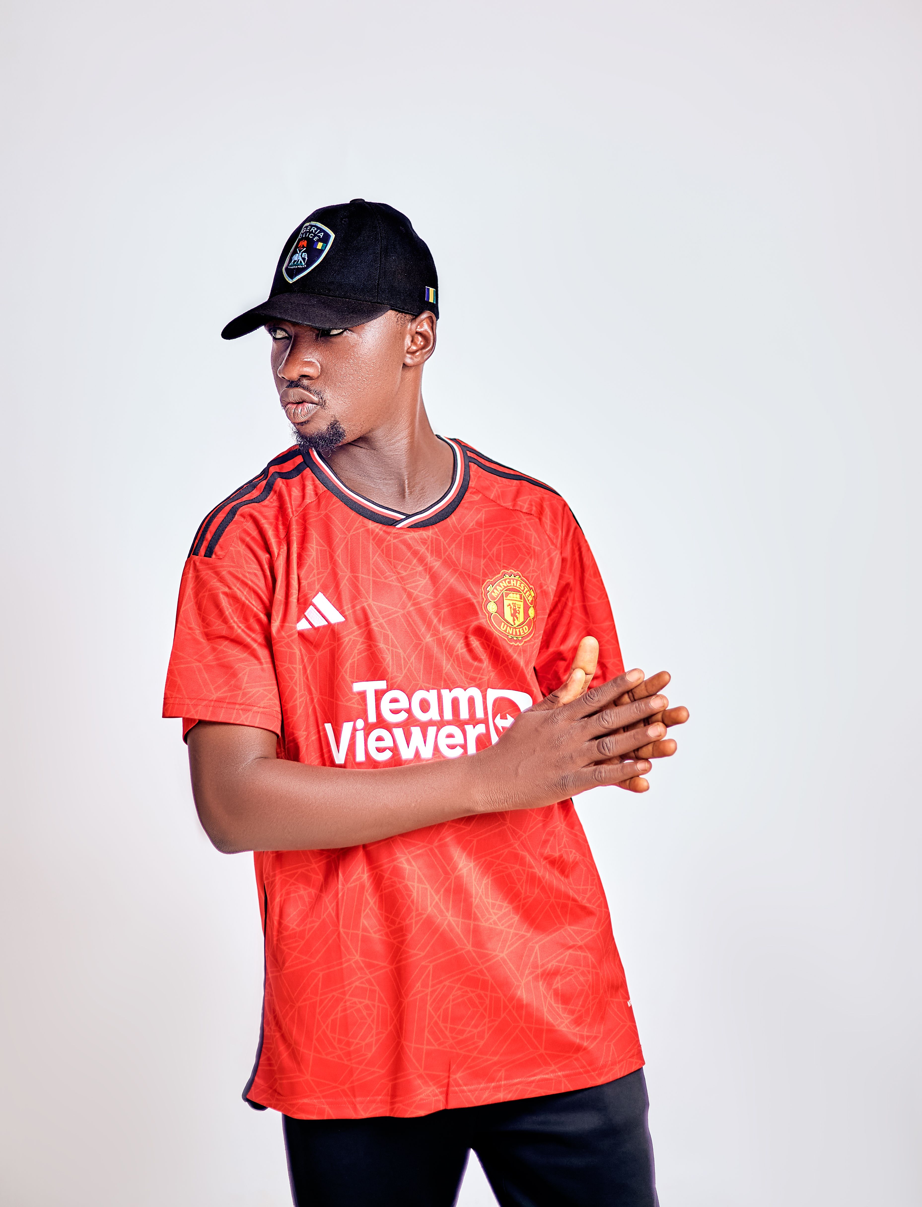 Casual portrait of a young man in sports attire with a cap in a studio setting.