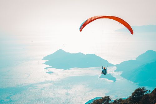 Free Adventurous paraglider glides over stunning coastal scenery, capturing exhilarating views and freedom. Stock Photo