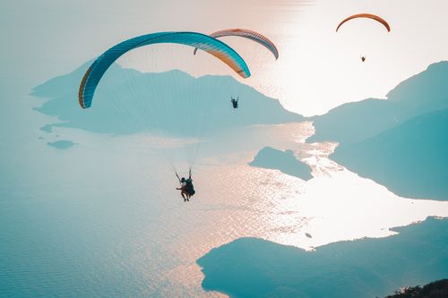 Free Experience exhilarating paragliding over a stunning coastal landscape with breathtaking views. Stock Photo