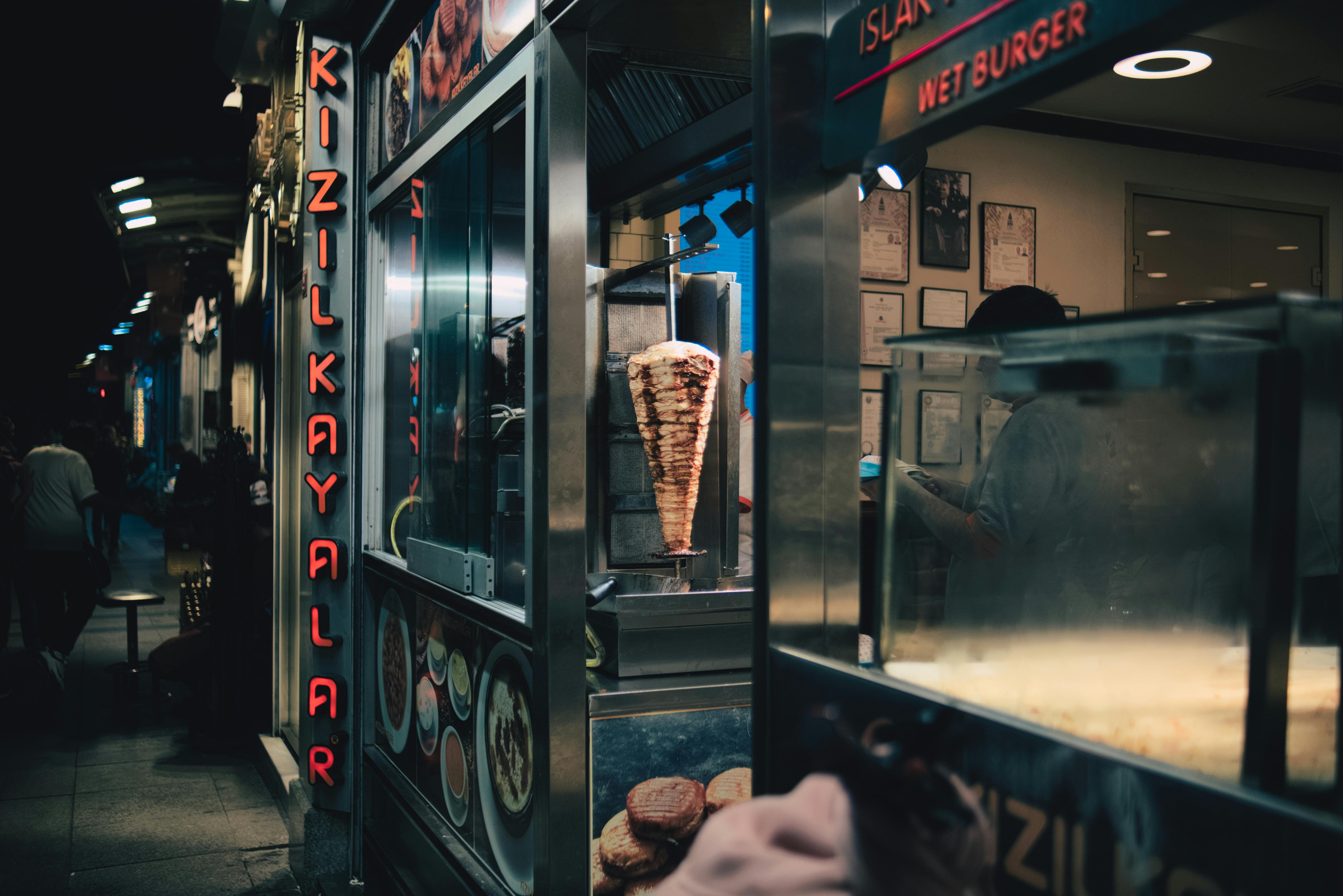 Gratis Una vivace scena notturna di un venditore ambulante turco di cibo da strada a Istanbul, con kebab e hamburger bagnati. Foto a disposizione