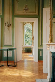 A peaceful room with classic architectural details and a sunlit view of a lush garden.