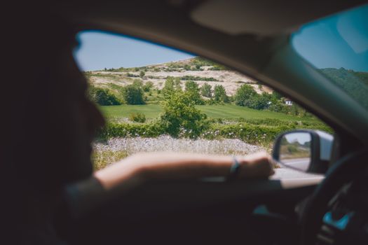 Relaxing drive with scenic countryside views through a car window on a sunny day.