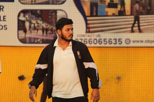 A cricket player on a turf field wearing a jacket with a focused look.