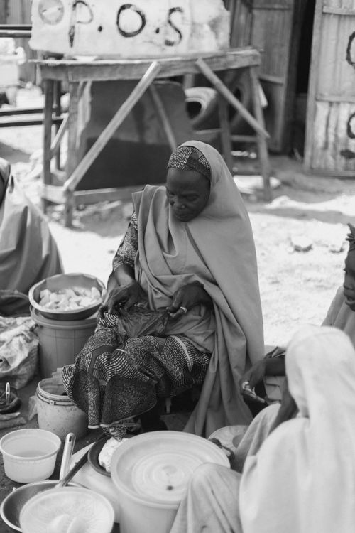 Free Black and white photo of women preparing food in outdoor market setting. Stock Photo