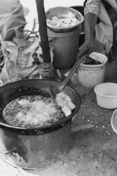 A monochrome image of street food frying, capturing local culinary art.