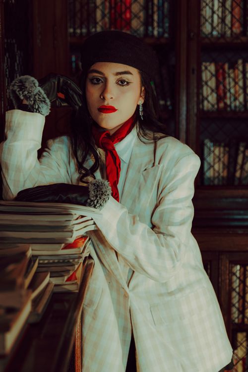 Free Sophisticated woman in vintage attire poses in an elegant library. Classic and timeless. Stock Photo