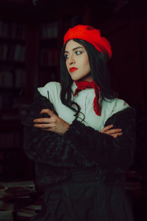 Free Stylish woman in a library with a red beret and scarf, exuding vintage charm. Stock Photo