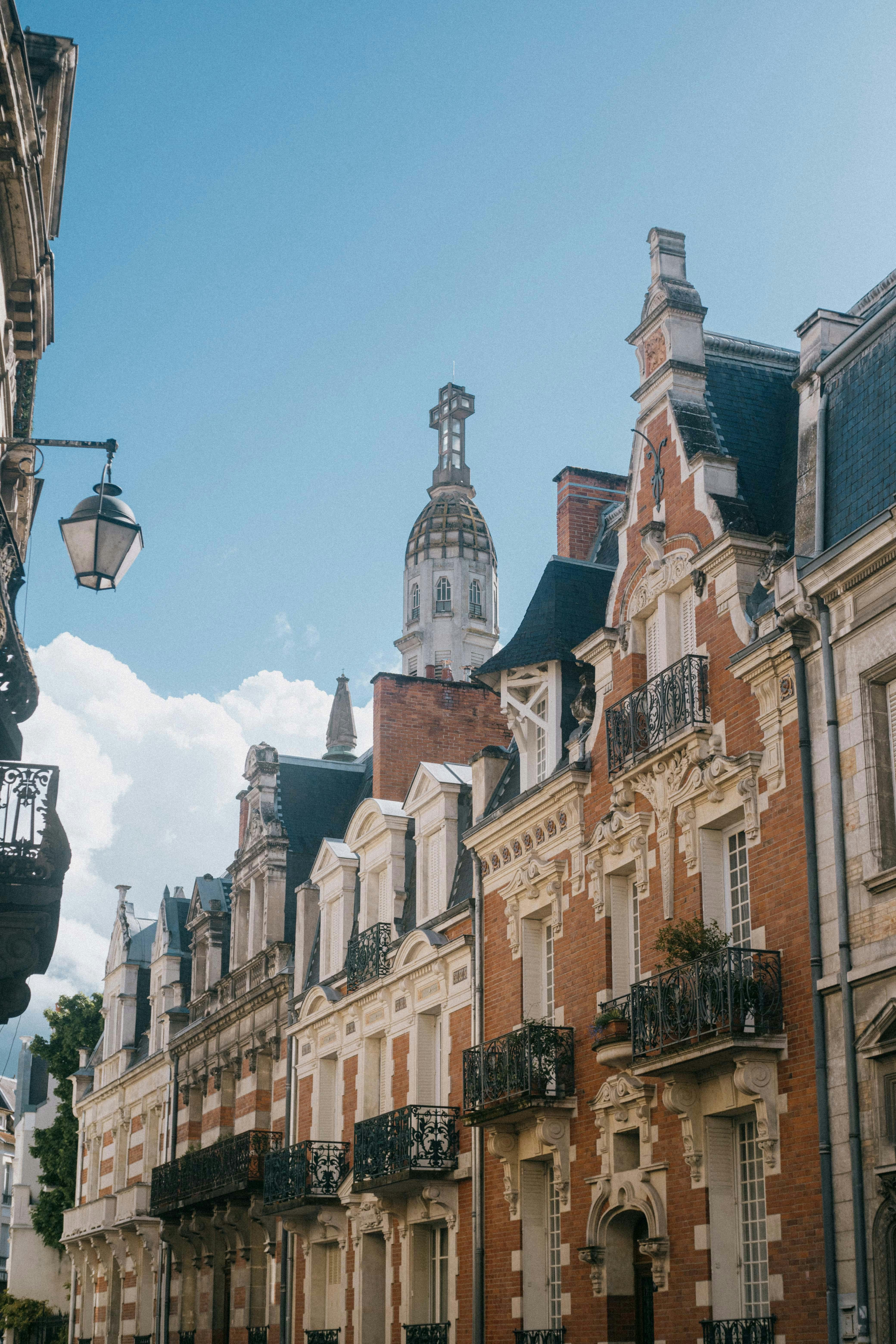 Charming view of historic European street with ornate facades under a clear blue sky.