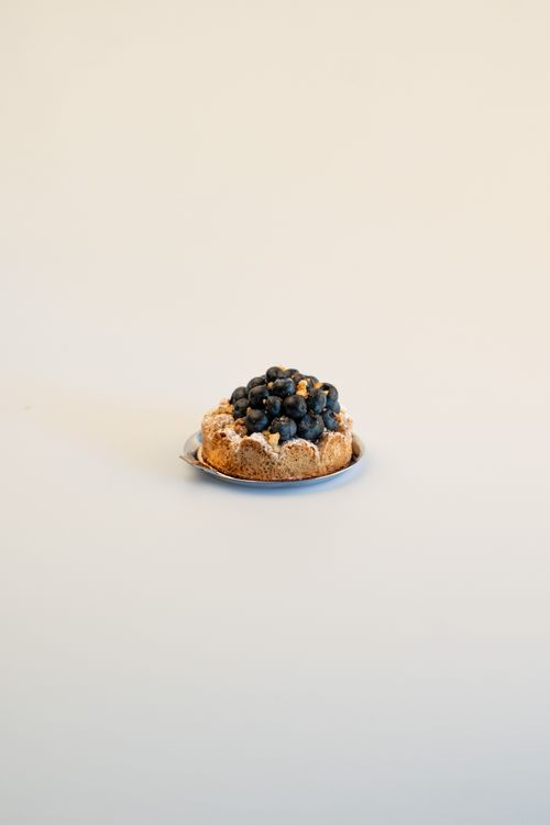 Free A fresh blueberry tart on a simple background, highlighting elegant European pastry. Stock Photo