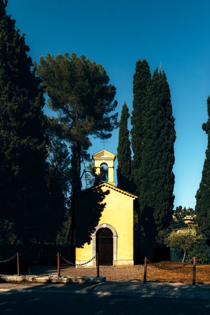 Serene yellow chapel amidst tall cypress trees in Vence, Provence-Alpes-Côte d'Azur, France.
