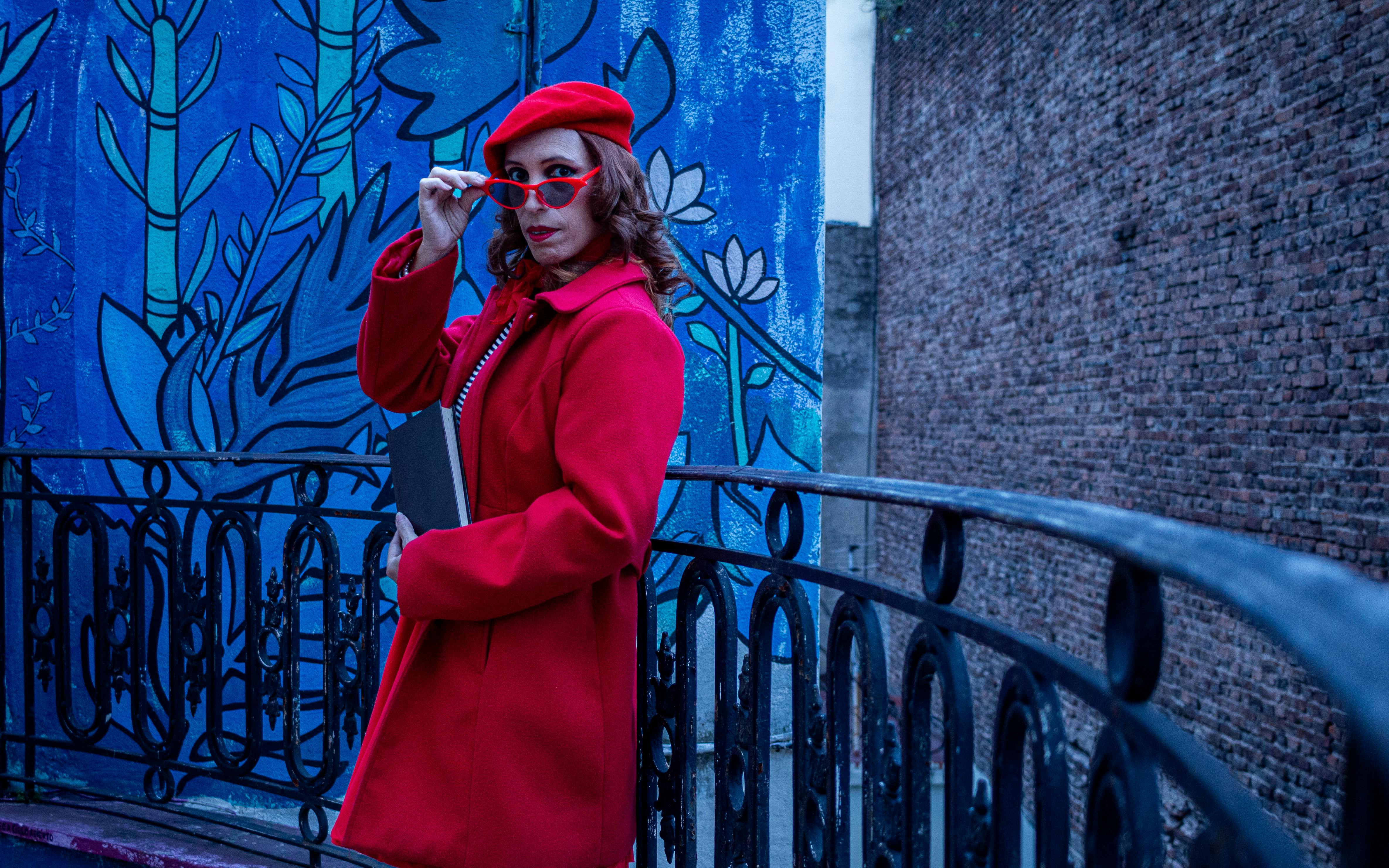 ingyenes Stílusos, piros ruhás nő egy színes Buenos Aires-i erkélyen. Városi művészet és divat. Stockfotó