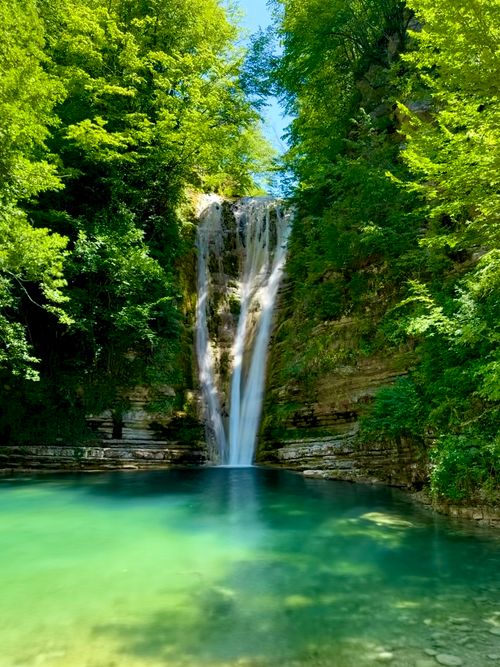 Free Stunning waterfall cascading into a turquoise pool surrounded by vibrant green forest. Stock Photo