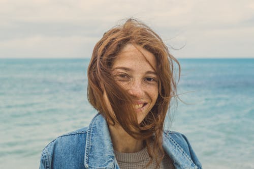 Portrait Photo of Smiling Woman with brown Hair Near Body of Water 