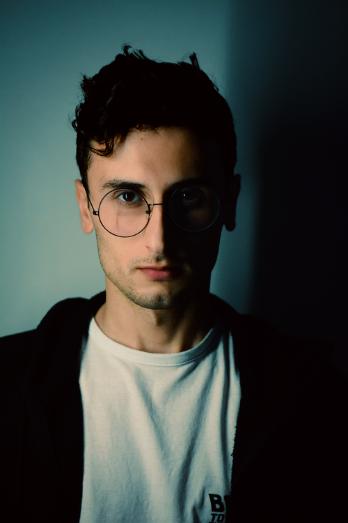 Free A dramatic portrait of a young man in glasses, exuding confidence and style. Stock Photo