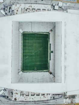 A top-down view of an empty soccer stadium showcasing its pristine green field and surrounding seating areas.