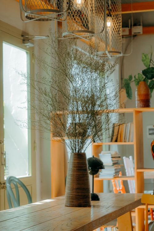 Free Elegant wooden table with vase in a sunny modern interior. Stock Photo