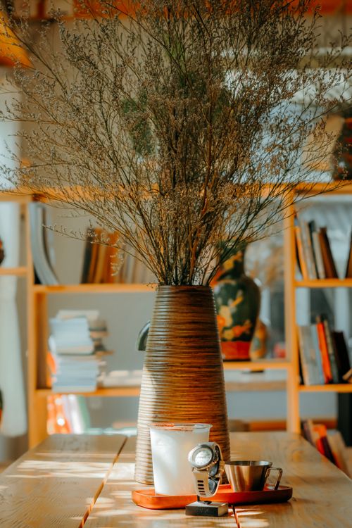 Free Cozy indoor scene with rustic vase and dried flowers on a wooden table. Stock Photo