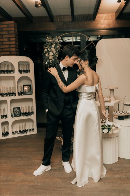 Free Bride and groom sharing a romantic moment at a beautifully decorated indoor wedding celebration. Stock Photo