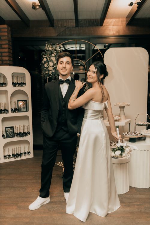Free Elegant wedding couple posing indoors with a modern decor backdrop, perfect for romantic event themes. Stock Photo