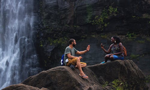 Man and Woman Talking Near Waterfalls