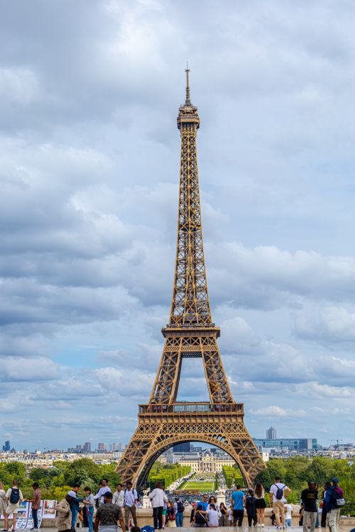 Free View of the Eiffel Tower in Paris with a crowd of tourists captured in daylight. Stock Photo