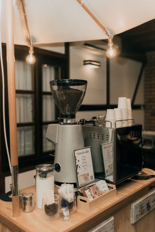 Free Warm interior view of a cafe with an espresso machine, grinder, and coffee cups. Stock Photo