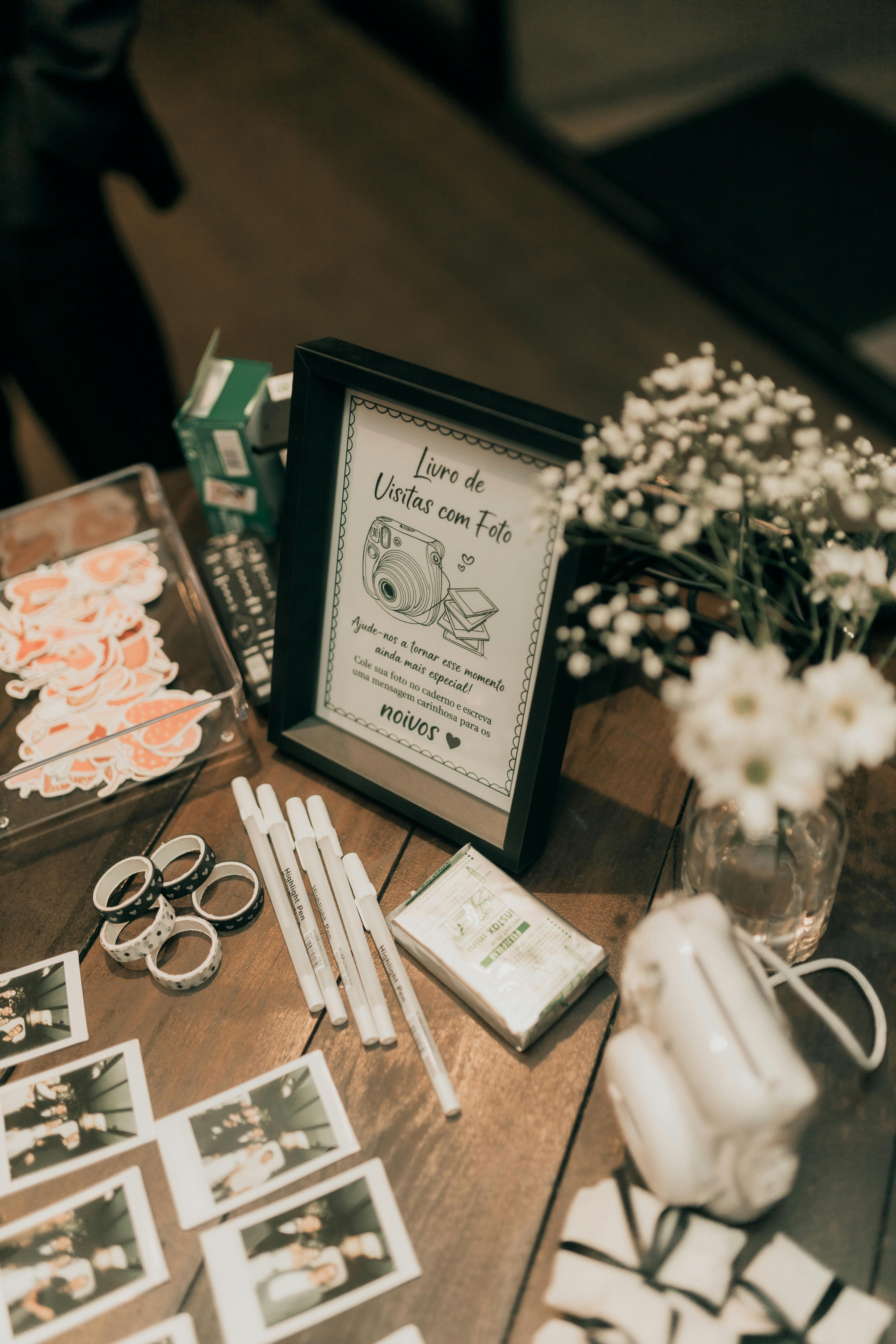 A charming table setup featuring instant photos, pens, and floral decor for a romantic event.