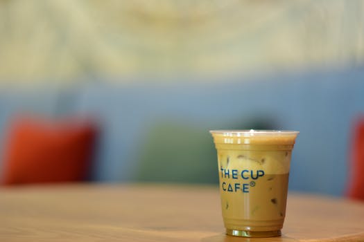 Refreshing iced coffee served in a cafe setting with blurred decor in the background.