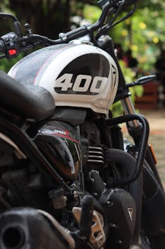 Detailed shot of a motorcycle featuring raindrops and classic design, captured outdoors in Chikkamagaluru, India.
