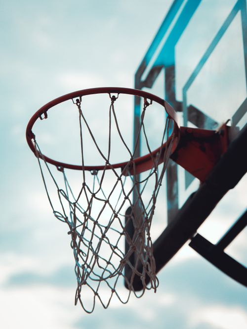 Free Close-up of a basketball hoop under a clear sky, emphasizing outdoor sports energy. Stock Photo