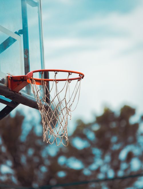 Free A close-up of an outdoor basketball hoop and net against a clear sky background. Stock Photo