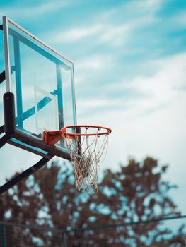 Basketball hoop outdoors under a blue sky, perfect for sports stock images.