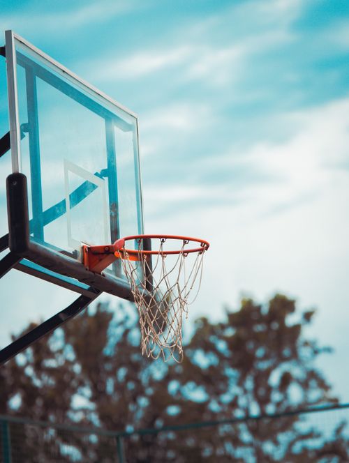Free Basketball hoop outdoors under a blue sky, perfect for sports stock images. Stock Photo
