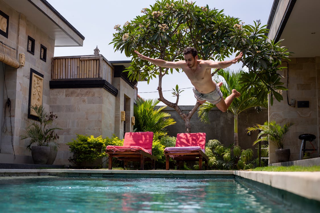 Free Man Jumping on Pool Stock Photo