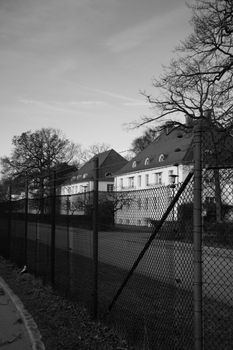 Black and white image of a historic building behind a fence in Dachau, Germany.