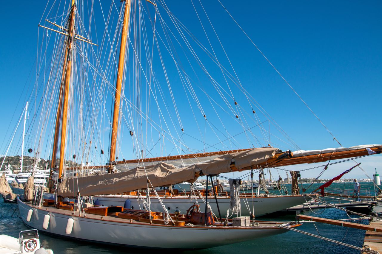 beautiful sailboats moored at a marina under a clear blue sky showcasi
