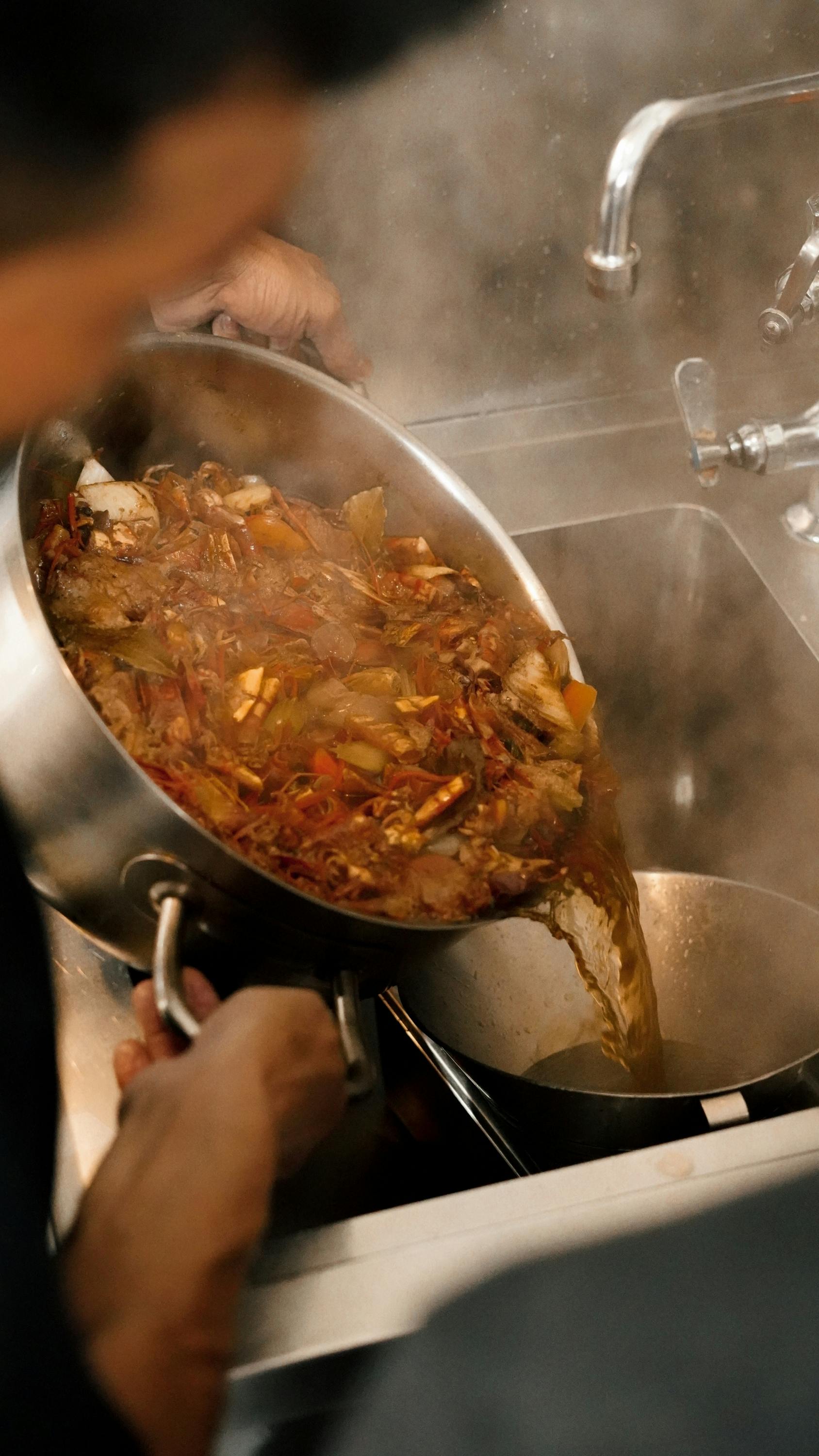 A variety of fresh seafood including prawns, mussels, and squid arranged on a wooden table with vibrant vegetables and aromatic spices.