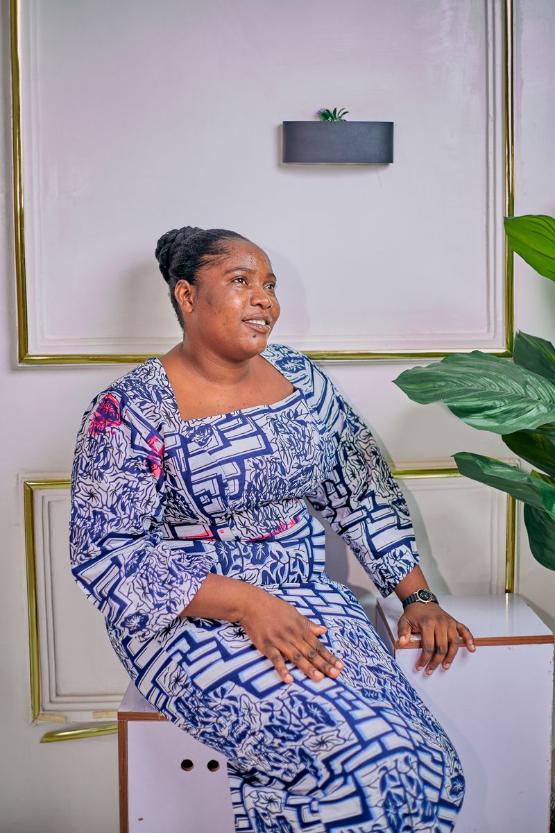 A woman in a floral dress is sitting on a couch · Free Stock Photo